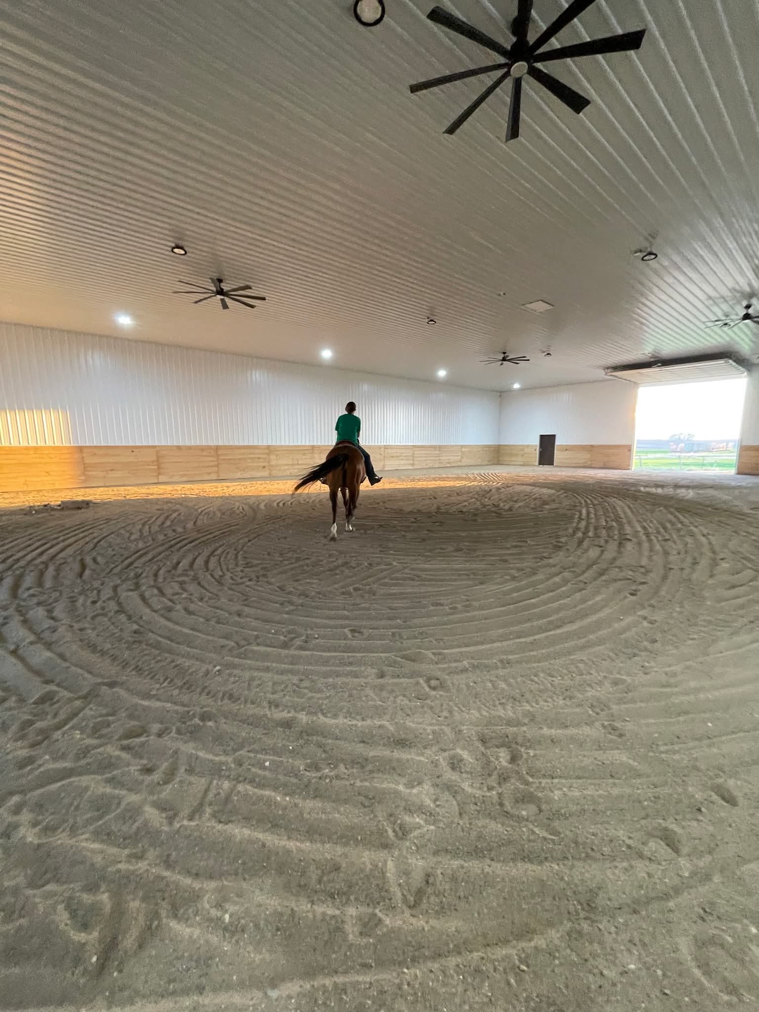 A rider loping across the indoor arena at Yahweh Arena